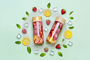 Strawberry infused water, cocktail, lemonade or tea. Summer iced cold drink with strawberry, lemon and lef of mint on green