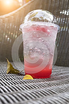 Strawberry italian soda with ice on wickerwork table