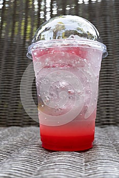 Strawberry italian soda with ice on wickerwork table