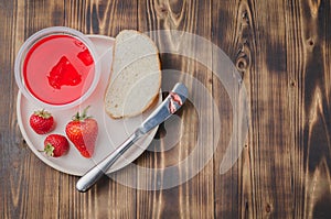 Strawberry jam. Bread and strawberry jam on a wooden table with jar of jam and fresh strawberry. Top view, copyspace. Making