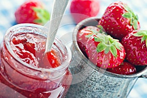 Strawberry jam in a glass jar and fresh strawberries