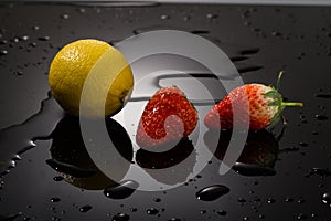 Strawberry and lemon on a black background