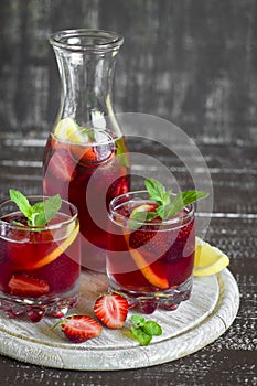 Strawberry lemonade with fresh mint and lemon in glass beakers