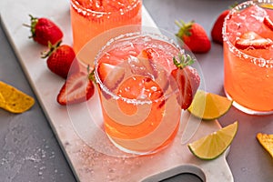 Strawberry margarita cocktail with lime and crushed ice