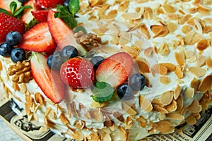 Strawberry meringue cake with almond petals, on newspaper