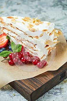 Strawberry meringue cake with almond petals, on newspaper