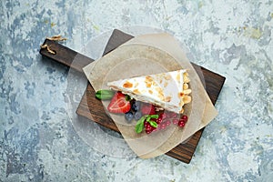 Strawberry meringue cake with almond petals, on newspaper