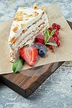 Strawberry meringue cake with almond petals, on newspaper