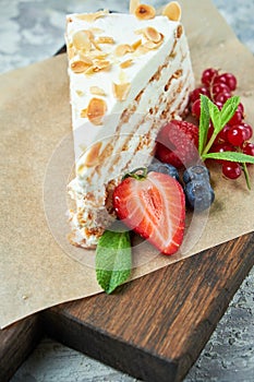 Strawberry meringue cake with almond petals, on newspaper