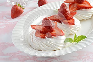 Strawberry meringue nests with mint on a platter