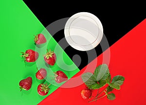 Strawberry, milk and green leaves on a colored background