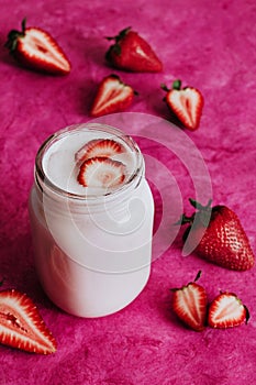 Strawberry milkshake in the glass jar pink background photo