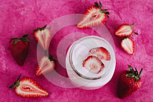 Strawberry milkshake in the glass jar pink background photo