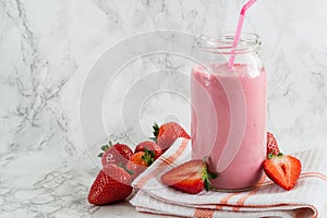 Strawberry milkshake in the glass jar on the table