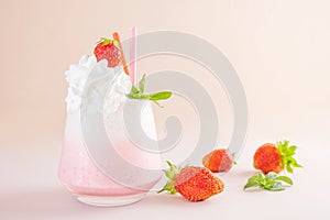 Strawberry milkshake on a light background in a transparent glass.