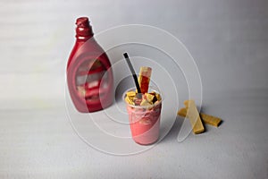 Strawberry Milkshake with straw and chocolate served in disposable glass isolated on grey background side view of healthy organic
