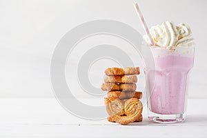 Strawberry milkshake with whipped cream and cookies Palmiers on white background, copy space for text. Valentine`s day concept