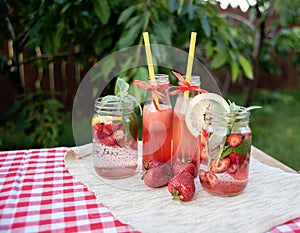 Strawberry and mint infused detox water. strawberry lemonade with ice and mint as summer refreshing drink in jars. Cold soft
