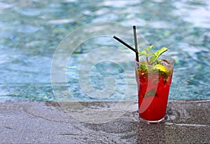 Strawberry Mojito cocktail at the edge of a resort pool. Concept of luxury vacation