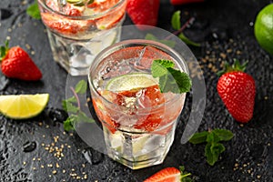 Strawberry Mojito cocktail with Rum, lime and mint in glass. Summer cold drink with ice