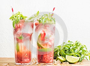 Strawberry mojito summer cocktails with mint and lime in tall glasses