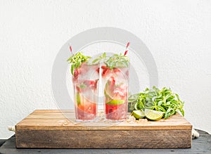 Strawberry mojito summer cocktails with mint and lime in tall glasses