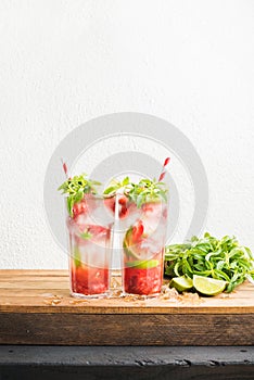 Strawberry mojito summer cocktails with mint and lime in tall glasses