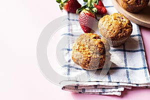 Strawberry muffins on a napkin on a pink background. Copy space