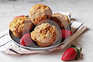 Strawberry muffins served in a plate on a marble background. Close up