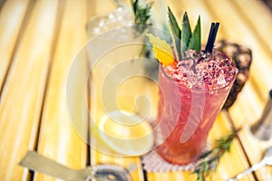 Strawberry pineapple alcoholic beverage, served cold with ice at bar. Cocktail drinks with lime, pineapple and alcohol as refr