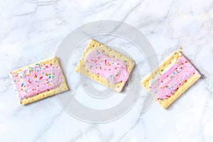 Strawberry pop tarts, shot from above on a white marble background