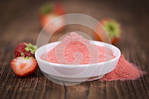 Strawberry powder on wooden background; selective focus