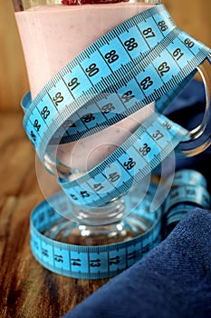 Strawberry protein cocktail in an Irish mug wrapped into a measure tape