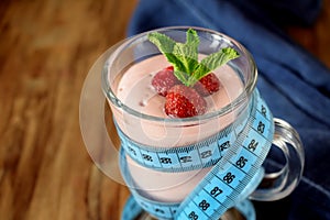 Strawberry protein cocktail in an Irish mug wrapped into a blue measure tape