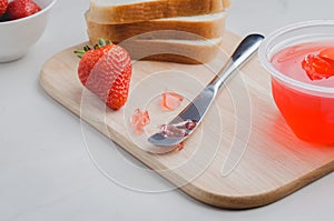 Strawberry pudding. Bread and strawberry pudding on a white table with jar of pudding and fresh strawberry