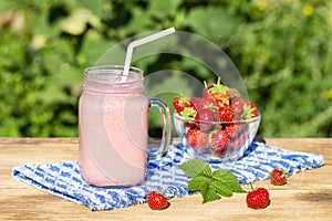 Strawberry, raspberries and banana juice smoothie shake in glass, outdoors, close up