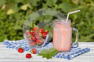 Strawberry, raspberries and banana juice smoothie shake in glass, outdoors, close up