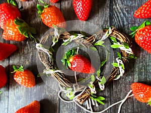 Strawberry red  heart-shaped  on wooden background table top wicker basket