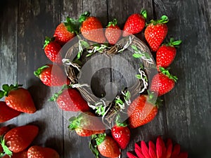 Strawberry red  heart-shaped  on wooden background table top wicker basket