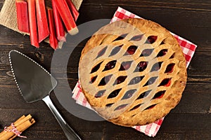 Strawberry and rhubarb pie on dark wood background