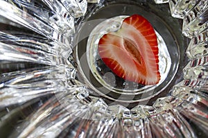 Strawberry sectioned in half in the shape of heart on abstract background