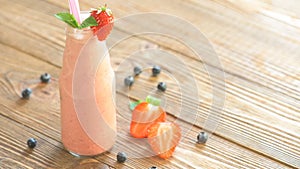 Strawberry shake in glass jar on the wooden table