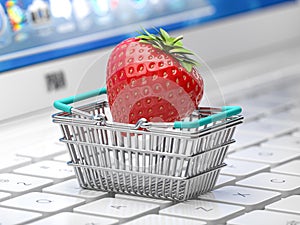 Strawberry in a shopping basket on laptop keyboard. Sex shop online or buying intimate content concept