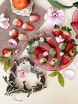 Strawberry  and slices  on white background ,table setting ,flowers in red cup ,and ,branch in heart shape still life