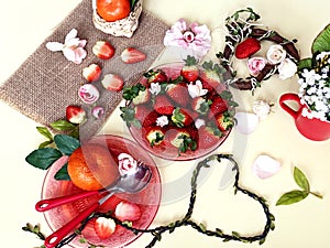 Strawberry  and slices  on white background ,table setting ,flowers in red cup ,and ,branch in heart shape still life