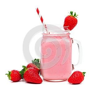 Strawberry smoothie in a mason jar with straw and berries over white