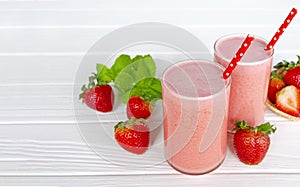 Strawberry smoothie or milkshake in jar, healthy food for breakfast and snack on white wood background.