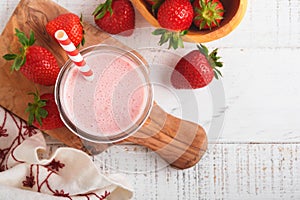 Strawberry smoothie. Vegan smoothie or milkshake from strawberry, banana and mint on white wooden table background. Clean eating,