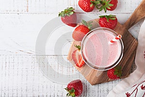 Strawberry smoothie. Vegan smoothie or milkshake from strawberry, banana and mint on white wooden table background. Clean eating,