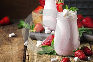 Strawberry smoothies and cocktails with fresh berry and green mint, decorated marshmallows, summer drink, wood old background,